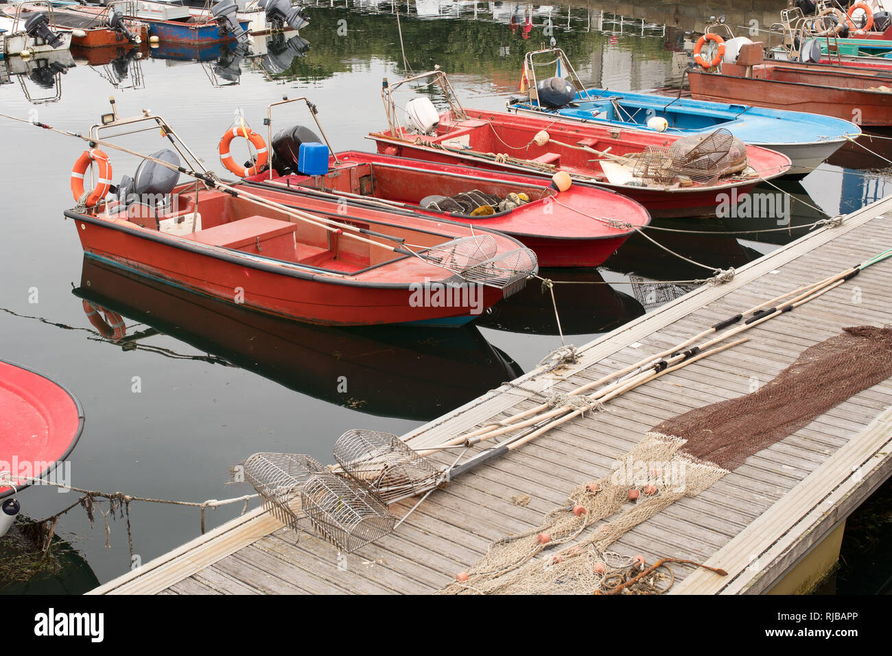 Il Clam acuaculture barche sul molo e alcuni clam utensili di scavo. Rias Baixas, Galizia Spagna Foto Stock