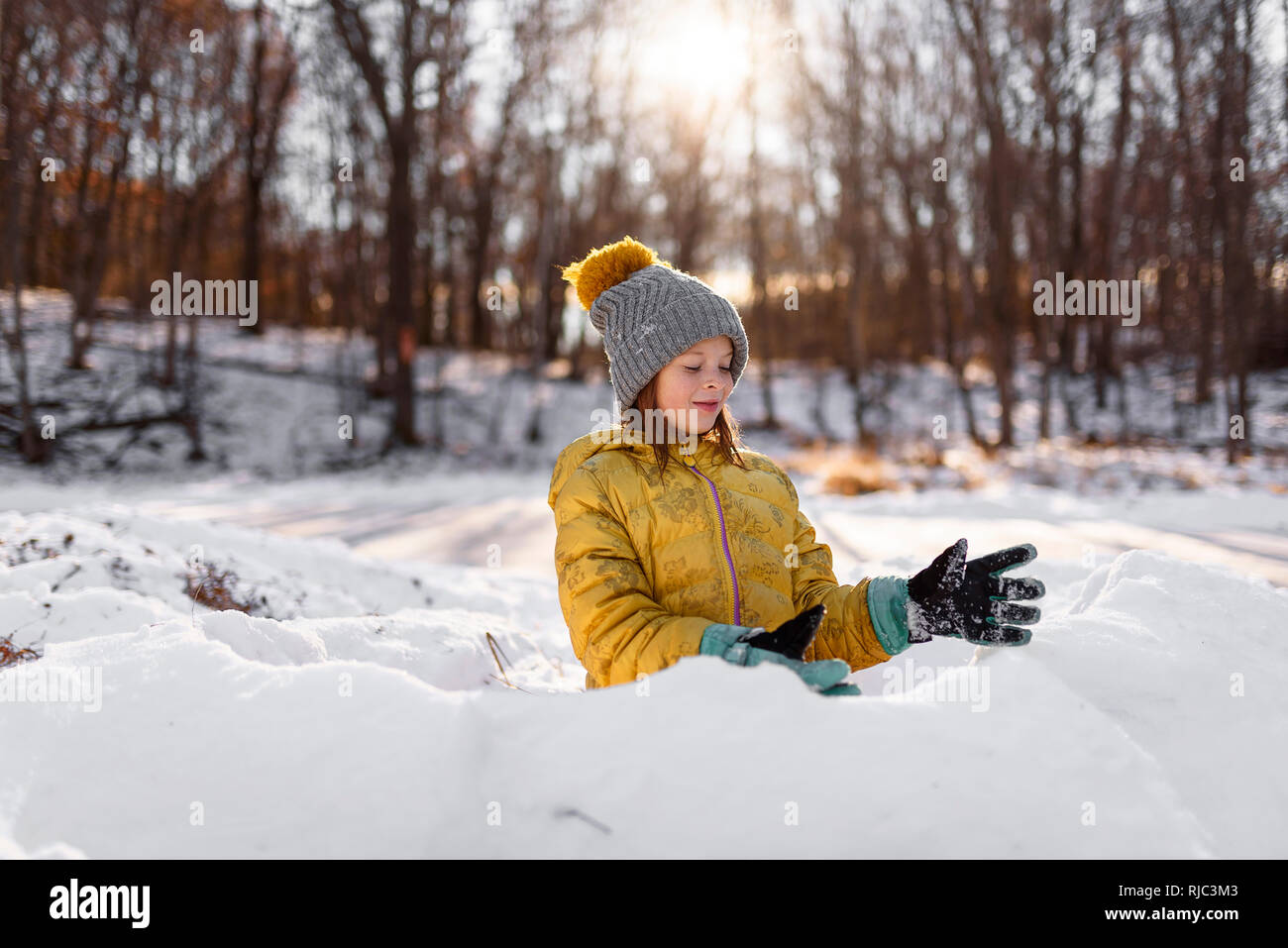 Ritratto di una ragazza sorridente costruire una neve fort, Stati Uniti Foto Stock