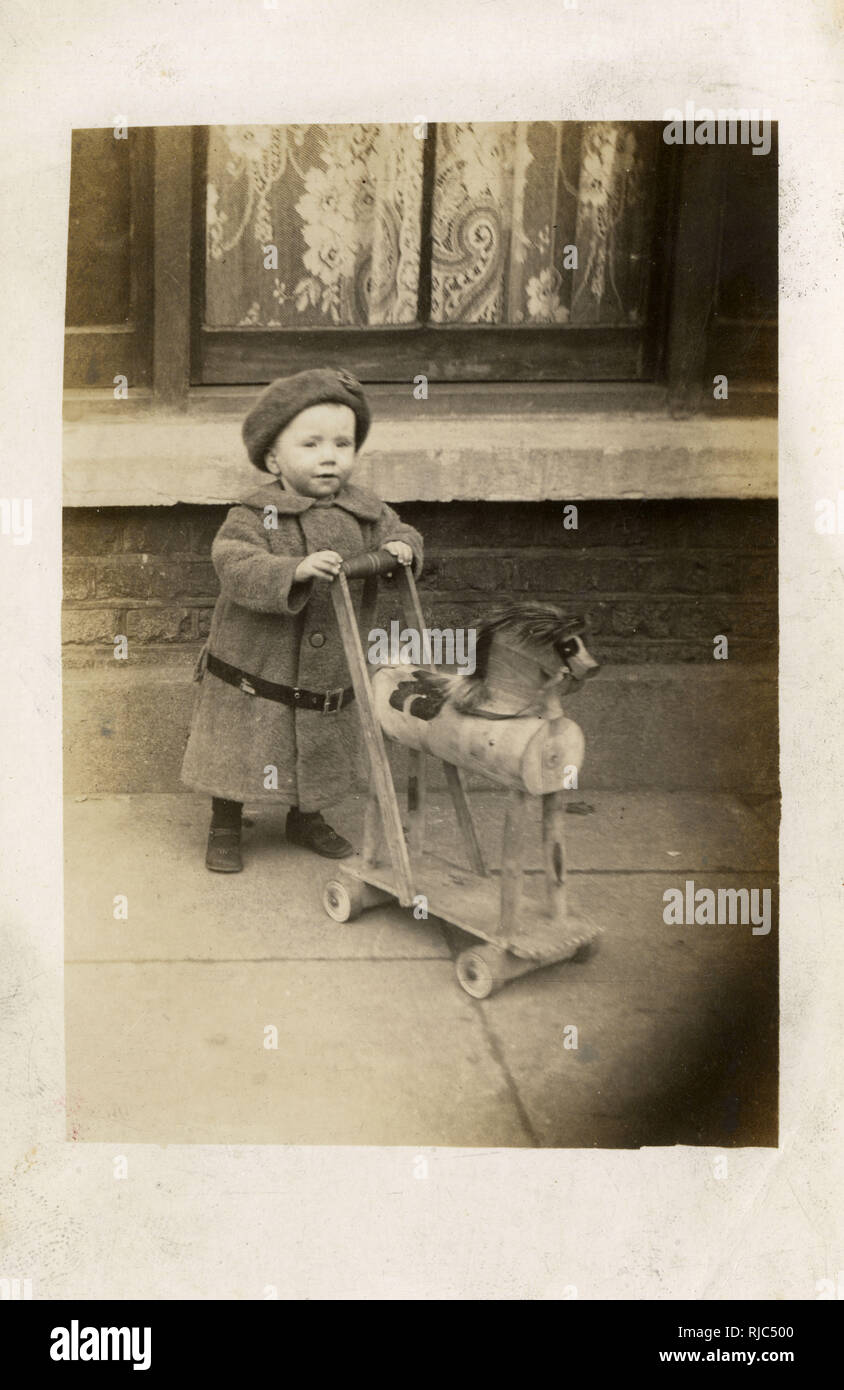 Little Georgie raggiungere spingendo il suo cavallo giocattolo - Blackpool Foto Stock