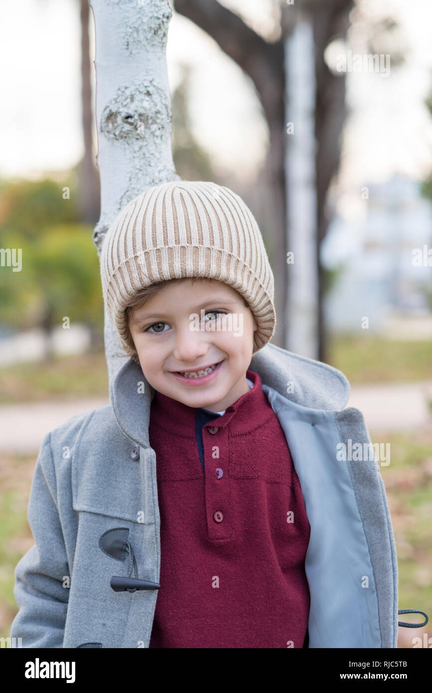 Ragazzo in posa con cappello di lana e vestiti caldi in un parco Foto stock  - Alamy
