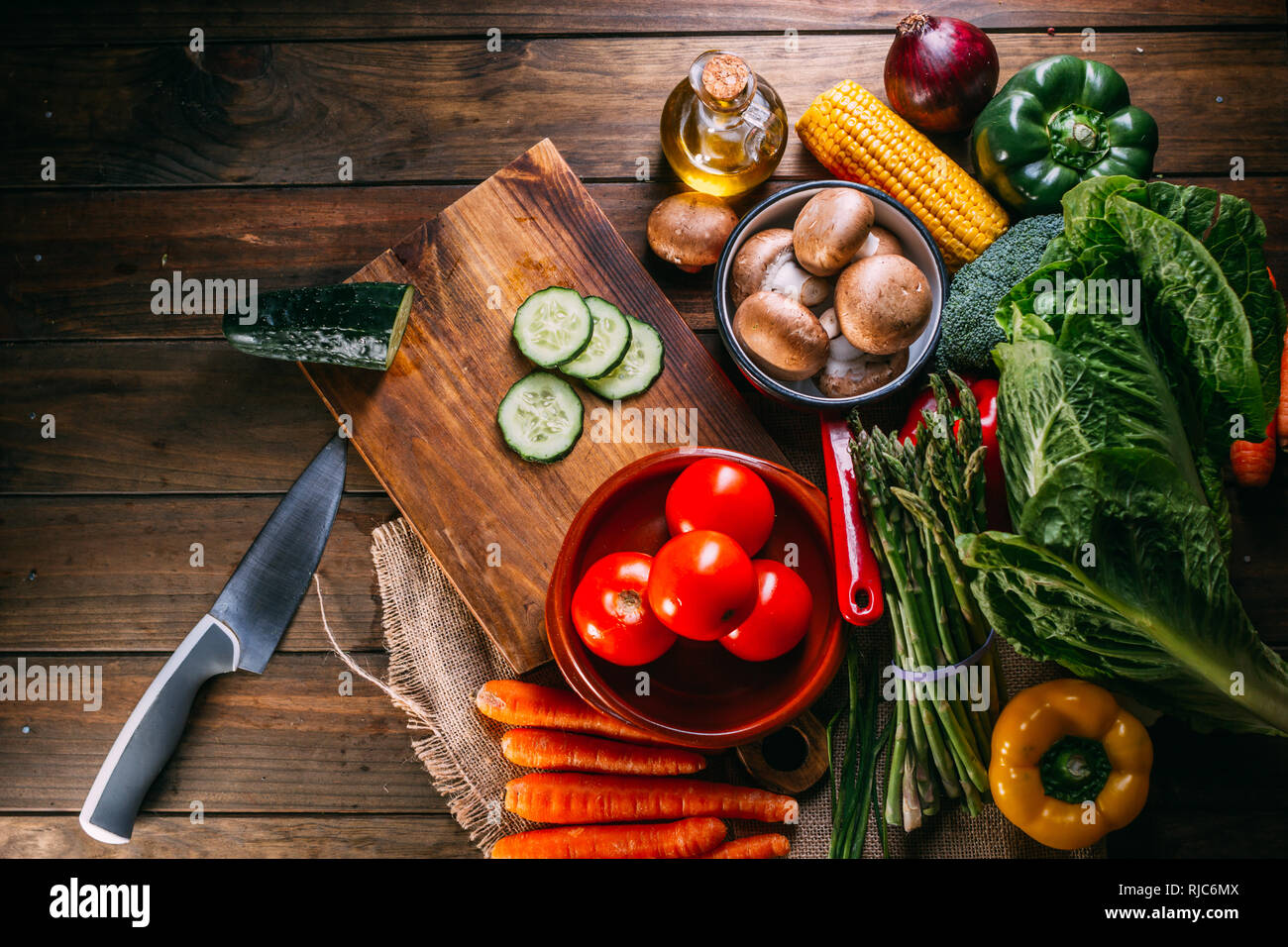 Da sopra un assortimento di verdure fresche giacente sul legname tavolo vicino a coltello affilato e il bordo di taglio Foto Stock