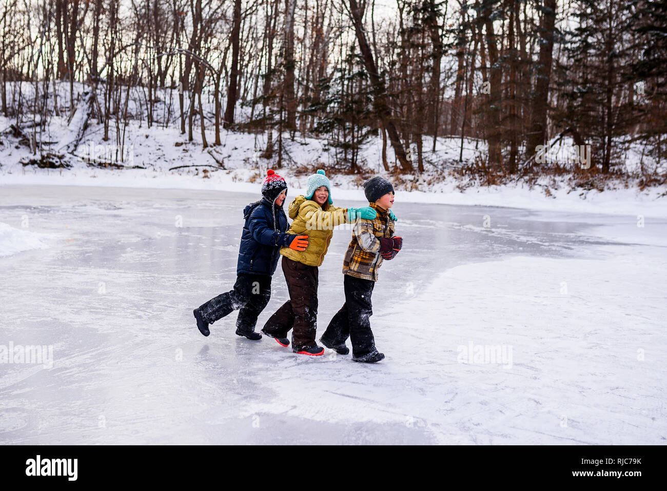 Tre bambini a camminare su un lago ghiacciato, Wisconsin, Stati Uniti Foto Stock