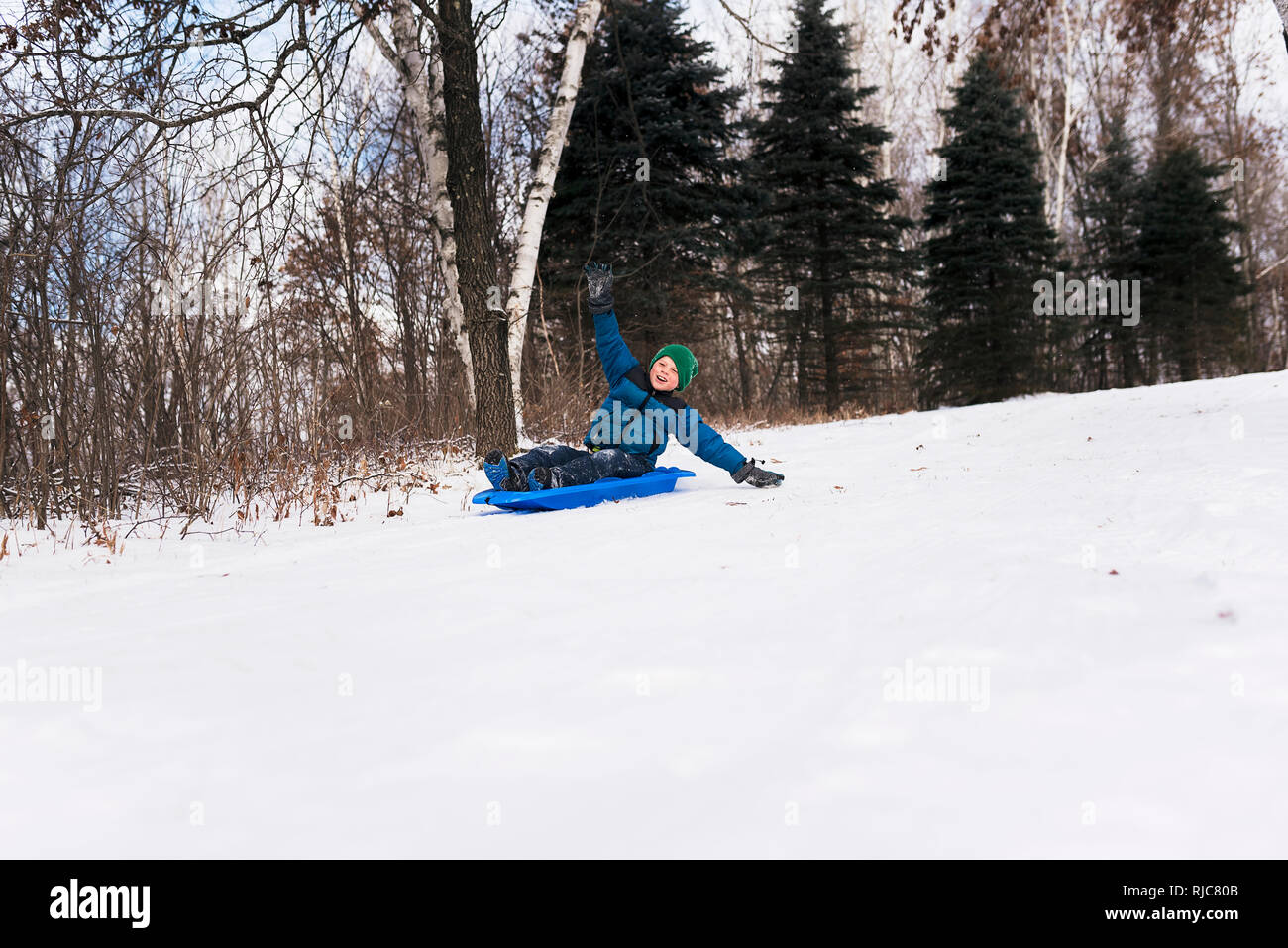 Ragazzo su una slitta a ridere, Wisconsin, Stati Uniti Foto Stock