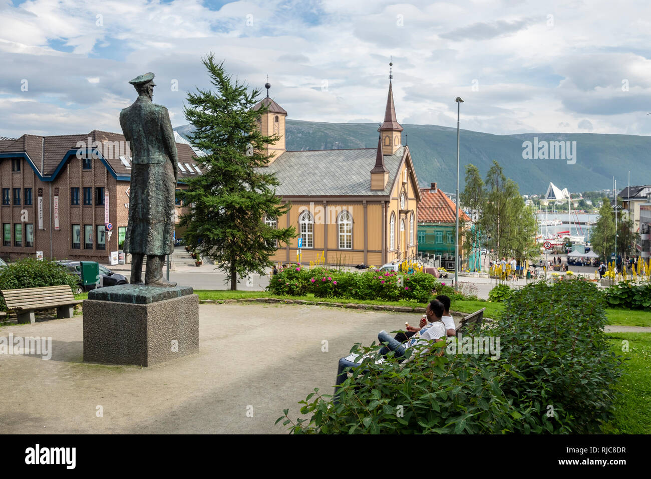 Tromsö centro, piccolo parco, chiesa cattolica "Tromsö stift', vista del porto e la cattedrale, all'altro lato del mare, Tromsö, Norvegia. Foto Stock