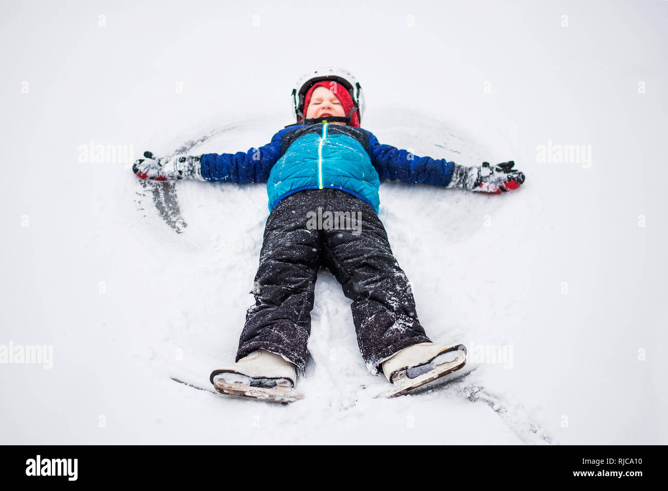 Ragazzo che giace in snow making un angelo di neve, Wisconsin, Stati Uniti Foto Stock