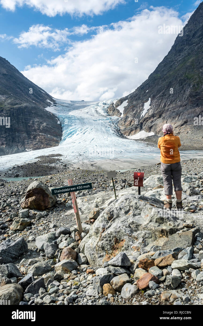 La donna a scattare foto, il ghiacciaio Steindalsbreen, lingua del ghiacciaio, segnaletica e 'trimkassa' alla fine della valle, Steindalen Lyngen Alpi, a sud di Lyngseidet Foto Stock