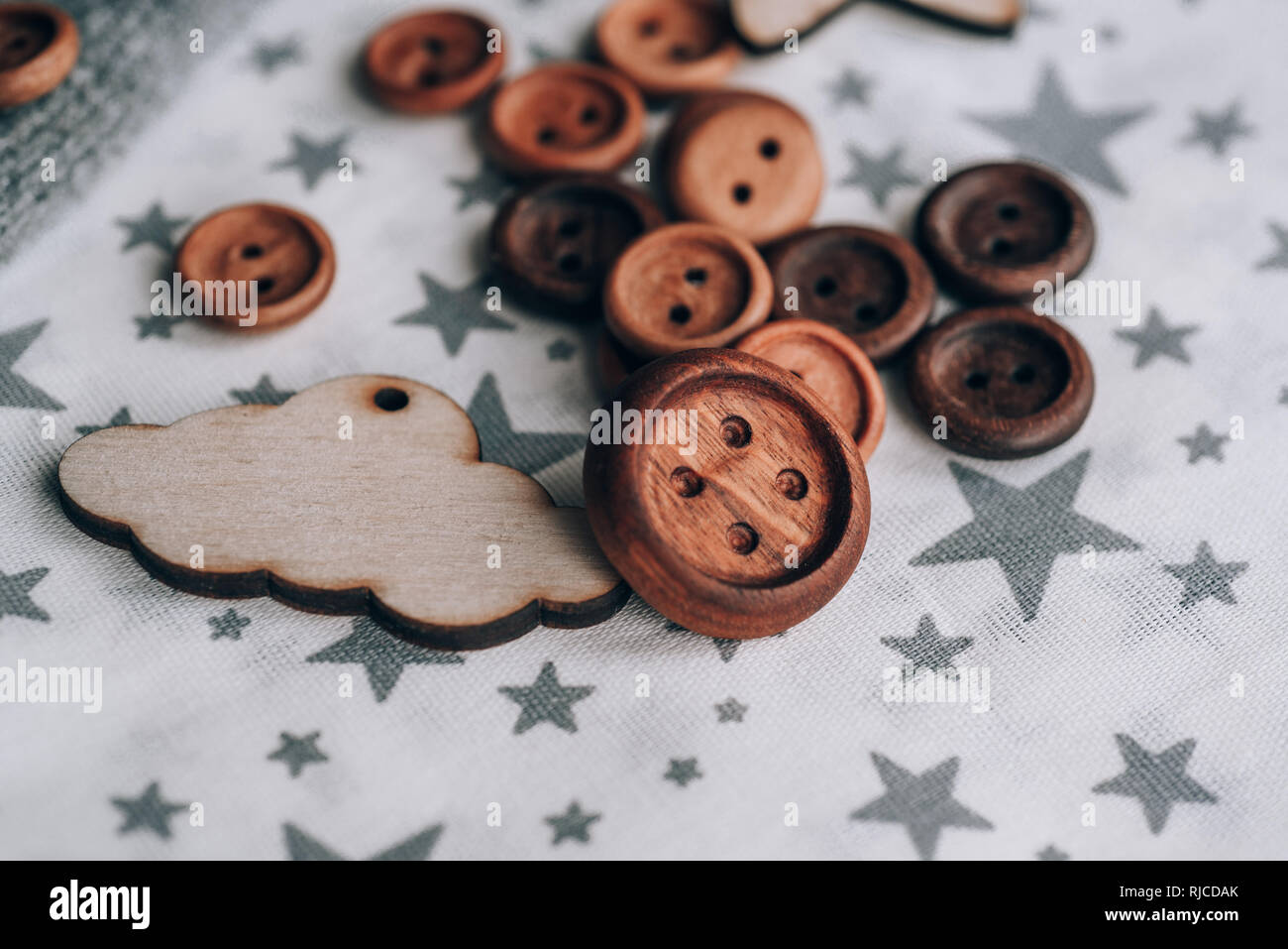 Pulsanti in legno fatti a mano a bellissimi tessuti di cotone in grigio stelle , bobine di filo. prossimo giocattolo di legno silhouette di agnello, stella, mese, montagna, cactus, C Foto Stock