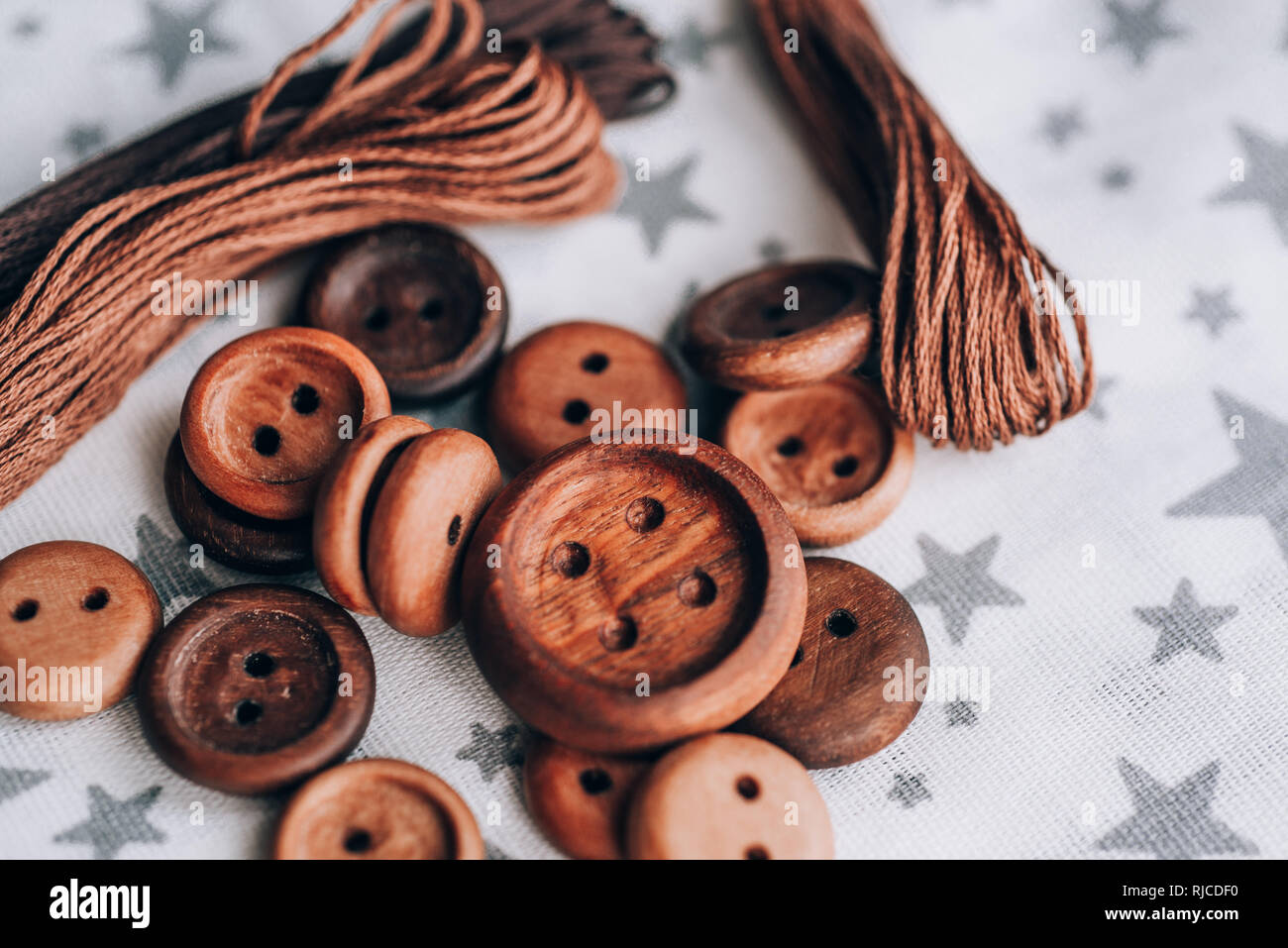 Pulsanti in legno fatti a mano a bellissimi tessuti di cotone in grigio stelle , bobine di filo Foto Stock