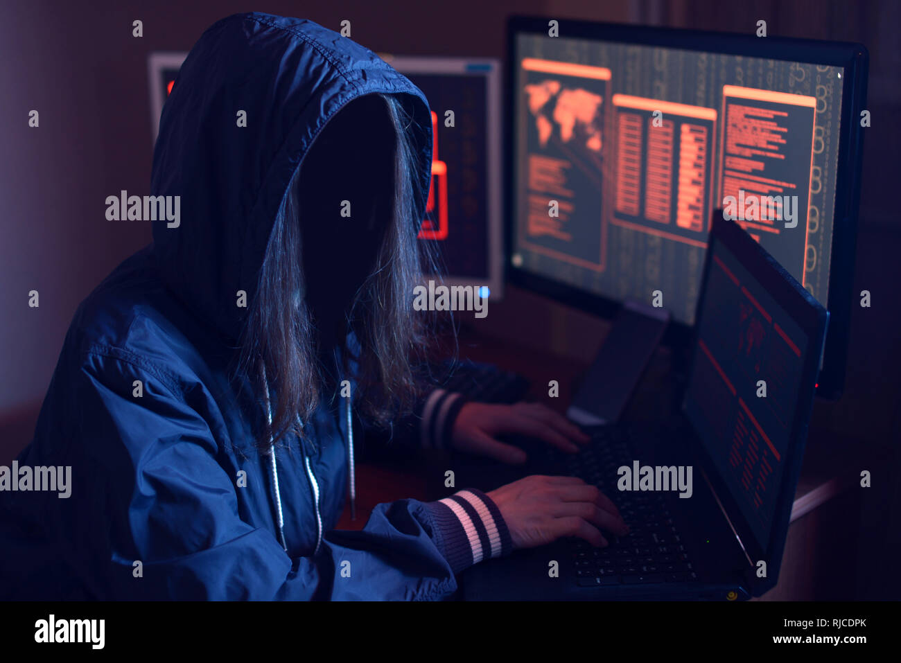 Anonimo hacker ragazza con nessun volto digitando il codice tenta di hack il sistema e rubare accede sullo sfondo le schermate di luce al neon. Il concetto di Foto Stock