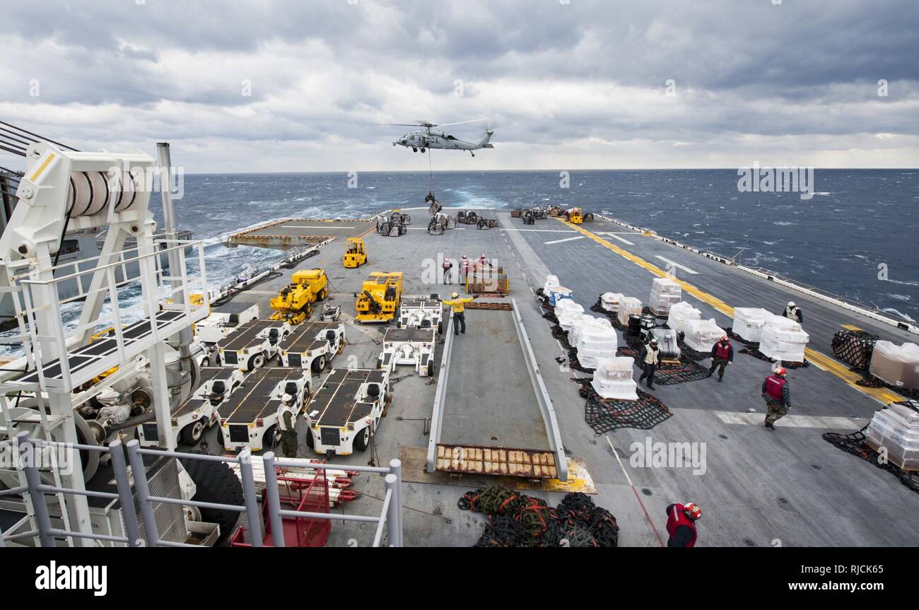 Oceano Pacifico (GEN. 12, 2018) Una SH-60S Sea Hawk elicottero conduce un rifornimento verticale a bordo dell'assalto anfibio nave USS Wasp (LHD 1) durante un rifornimento in mare (RAS) con il trasporto di carichi secchi e munizioni nave USNS Wally Schirra (T-AKE 8). Vespa è in transito a Sasebo, Giappone per condurre un fatturato con la USS Bonhomme Richard (LHD 6) come distribuita ammiraglia delle forze anfibio NEGLI STATI UNITI 7 flotta area di operazioni. Foto Stock