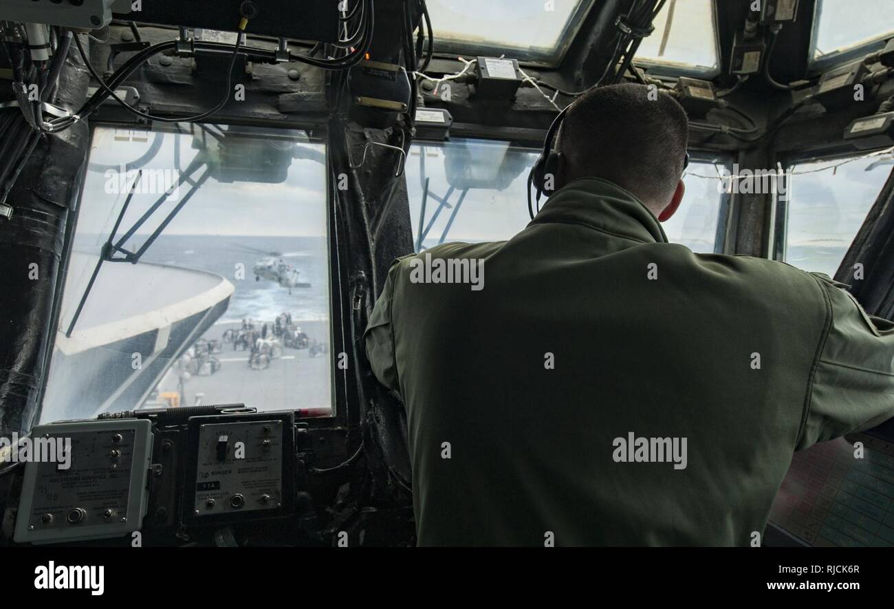 Oceano Pacifico (GEN. 12, 2018) Lt. Christopher Danielczyk osserva come un SH-60S Sea Hawk elicottero conduce un rifornimento verticale a bordo dell'assalto anfibio nave USS Wasp (LHD 1) durante un rifornimento in mare (RAS) con il trasporto di carichi secchi e munizioni nave USNS Wally Schirra (T-AKE 8). Vespa è in transito a Sasebo, Giappone per condurre un fatturato con la USS Bonhomme Richard (LHD 6) come distribuita ammiraglia delle forze anfibio NEGLI STATI UNITI 7 flotta area di operazioni. Foto Stock