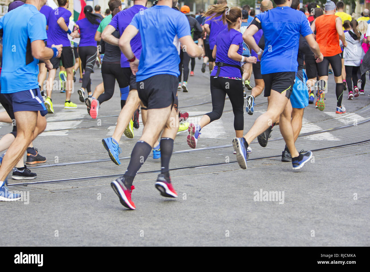 Corridori della maratona corsa per piedi di persone sulla strada della città Foto Stock