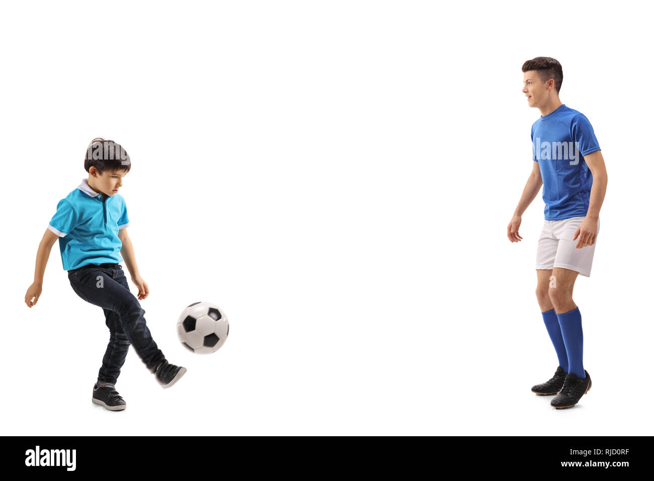 A piena lunghezza shot di un ragazzino che giocano a calcio con un vecchio ragazzo isolato su sfondo bianco Foto Stock