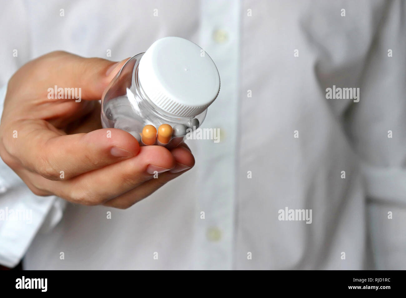 Medico dando bottiglia con le pillole, farmaci in capsule. Concetto di esame medico, la dose dei farmaci, vitamine, sedativi, farmacia Foto Stock