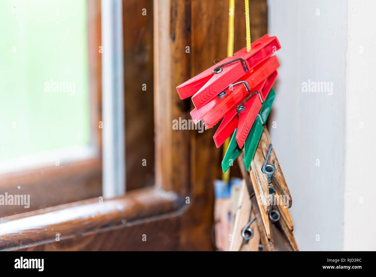 Primo piano di molti rosso e verde clothespins in legno per appendere gli abiti in estate da una finestra in stile rustico paese retrò home dacha in Ucraina o in Russia Foto Stock