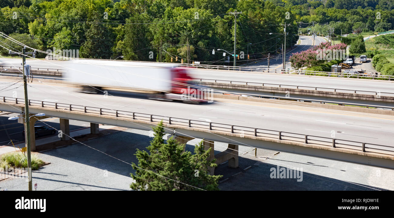 Un semi carrello attraversando un ponte prese con una lenta velocità di otturazione per mostrare il movimento e la velocità. Foto Stock