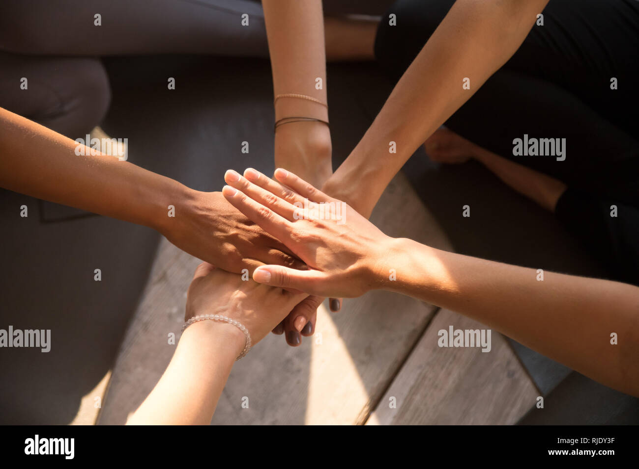 Vista superiore della pila di donne le mani impegnate in attività di team building Foto Stock