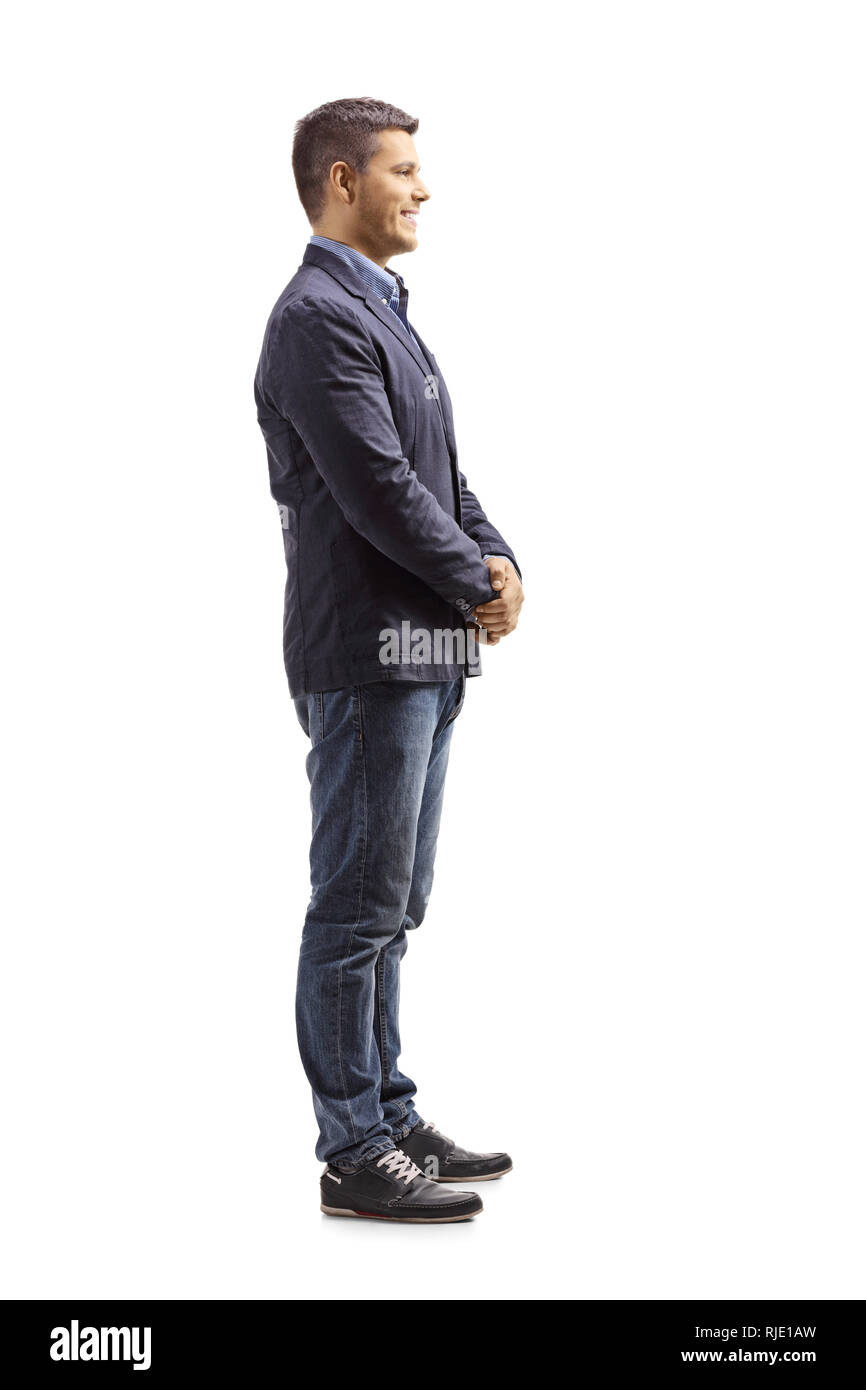 Lunghezza piena ripresa di profilo di un giovane uomo in piedi e sorridente isolati su sfondo bianco Foto Stock