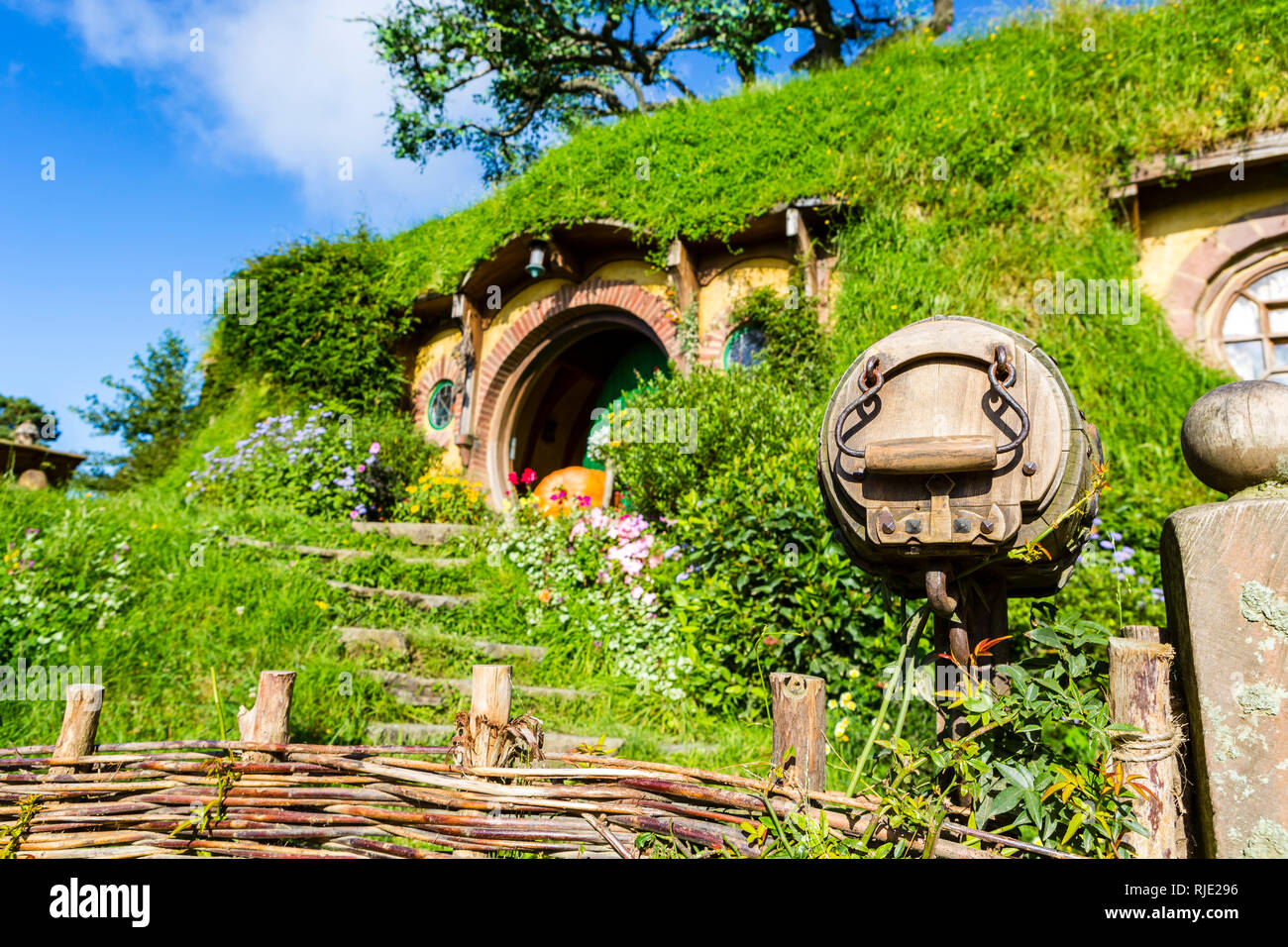 MataMata, Nuova Zelanda - Marzo 2017 Hobbit house con un bellissimo giardino verde in estate Hobbiton Foto Stock