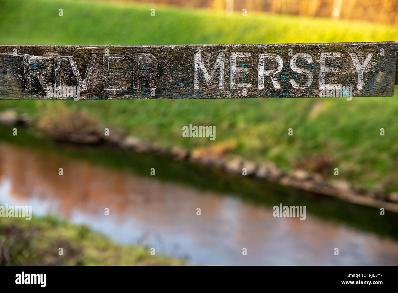 Un vecchio di legno dipinto di fiume Mersey firmare con il fiume Mersey in background accanto a Chortlon Water Park. Foto Stock
