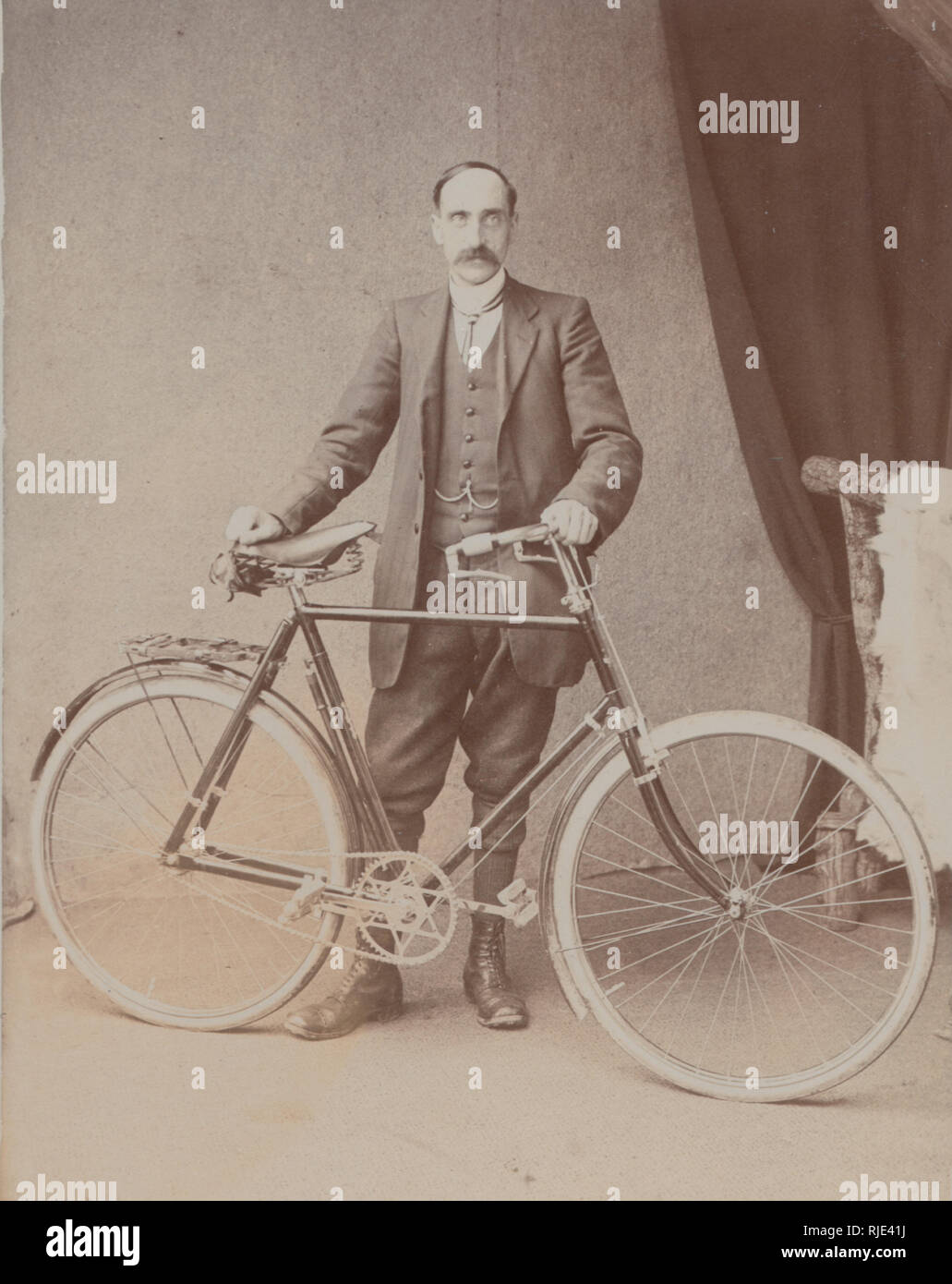 Vintage Edwardian Cartolina fotografica di un uomo adatto tenendo un ciclo di pedale. Foto Stock