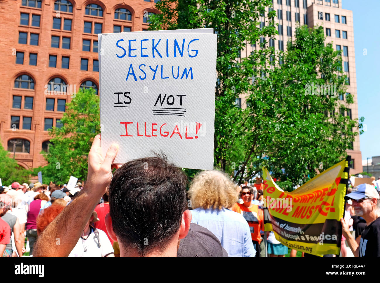 'Seeking asilo non è illegale" segno è detenuto da un uomo a giugno 30, 2018 protesta in Cleveland, Ohio, Stati Uniti d'America mobilitazione contro Trump le politiche di immigrazione. Foto Stock