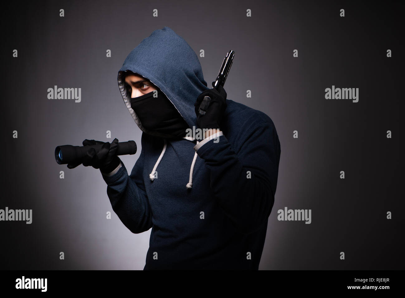 Giovani gangster in cappa su sfondo grigio Foto Stock