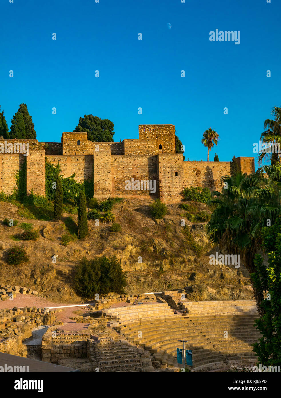 Alcazaba palazzo fortificato di mura al tramonto con la Luna in cielo, Malaga, Spagna Spagna Foto Stock