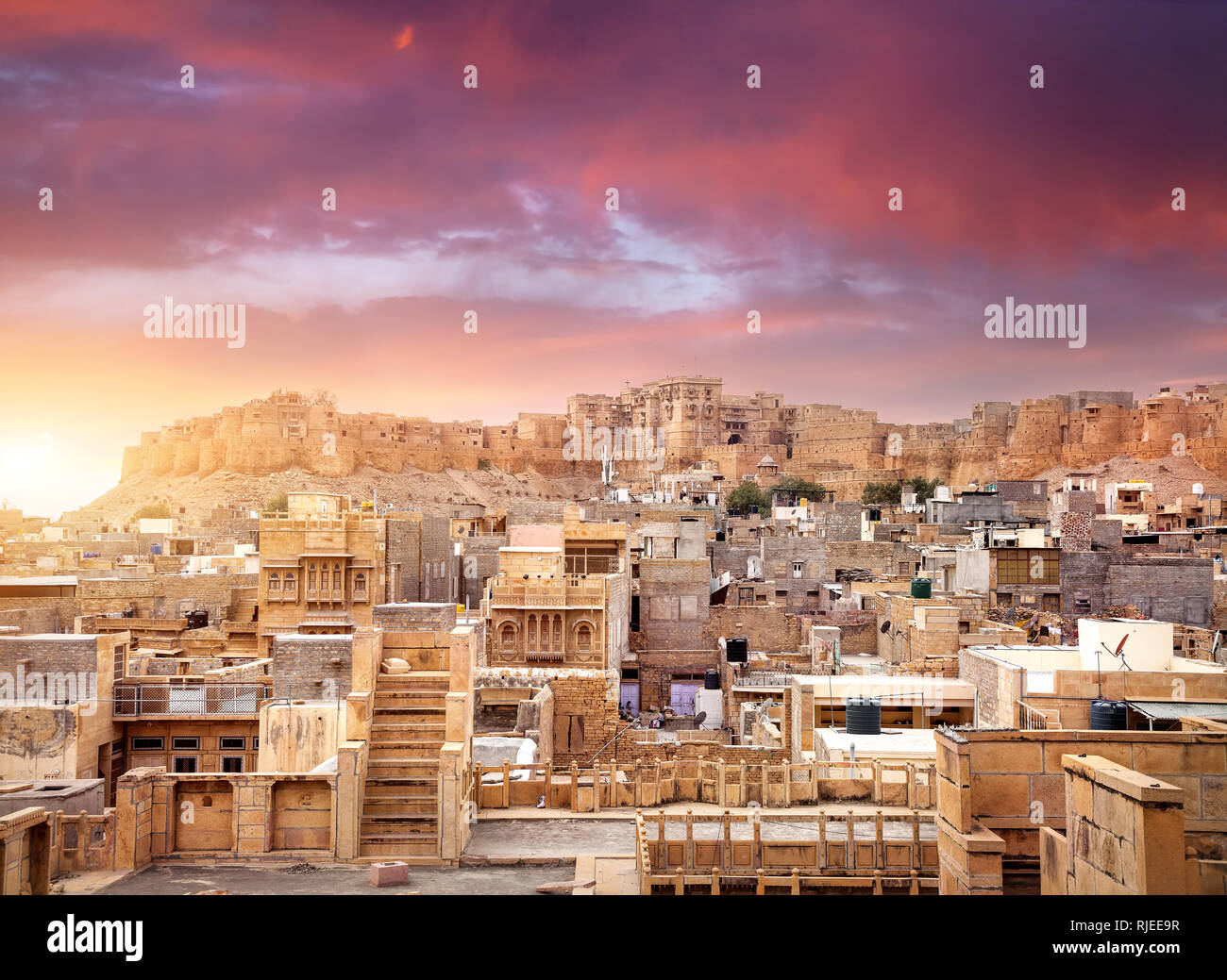 Viola vibrante tramonto nel deserto indiano città con Jaisalmer fort nel Rajasthan, India Foto Stock