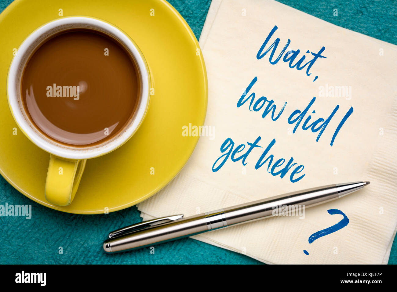 Attendere, come ho fatto ad ottenere qui ? Scrittura su un tovagliolo con una tazza di caffè Foto Stock