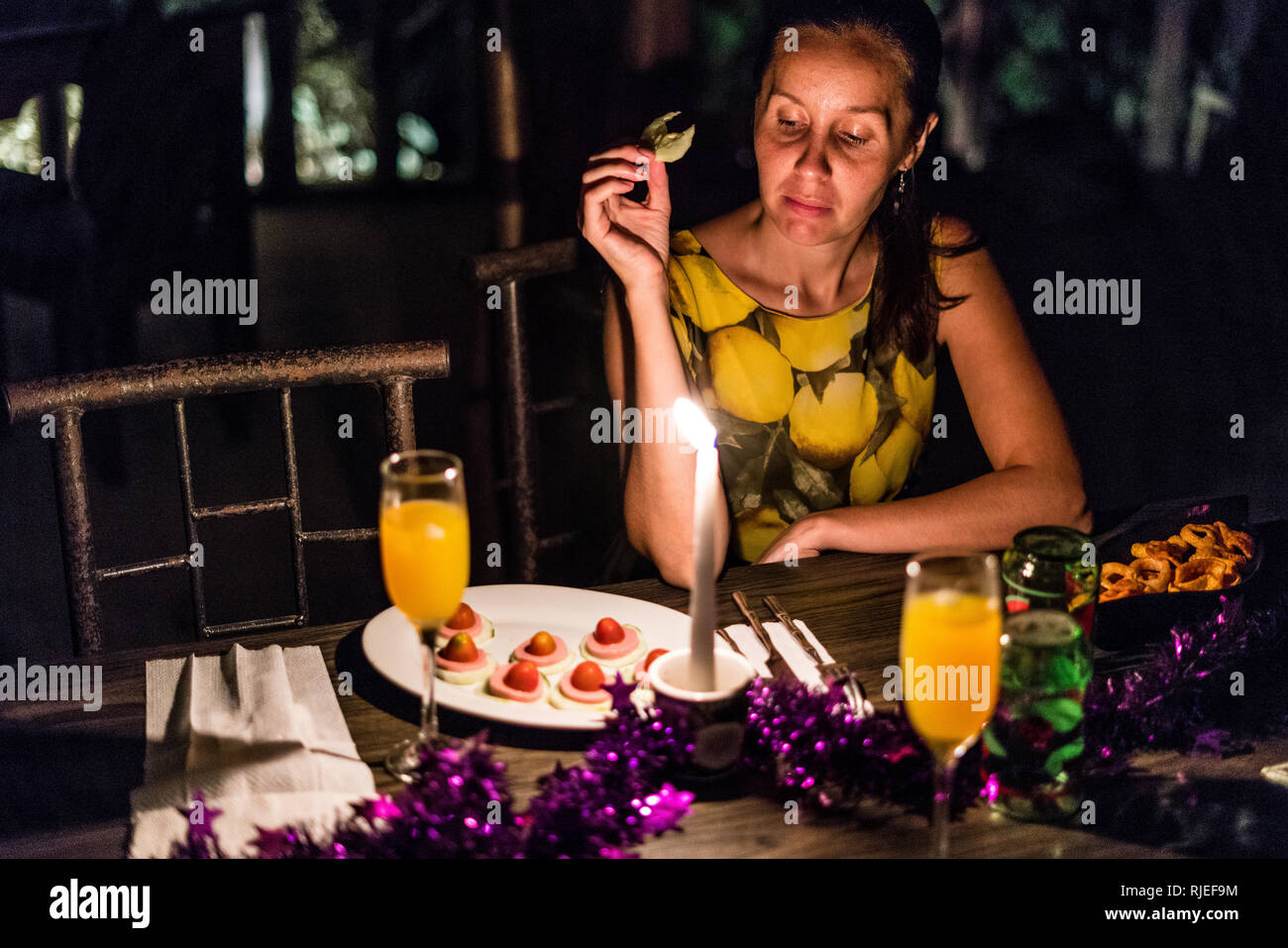 Un bel ritratto di una donna bellissima degustazione antipasto di lei durante una romantica cena in un ristorante di una foresta pluviale tropicale del Costa Rica Foto Stock