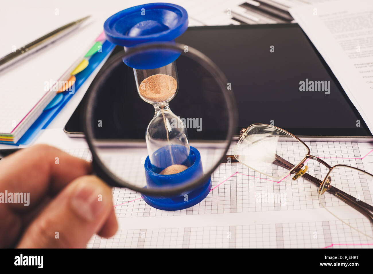 Clessidra. Imprenditore lavora in ufficio in background. Concetto il tempo è denaro. Foto Stock