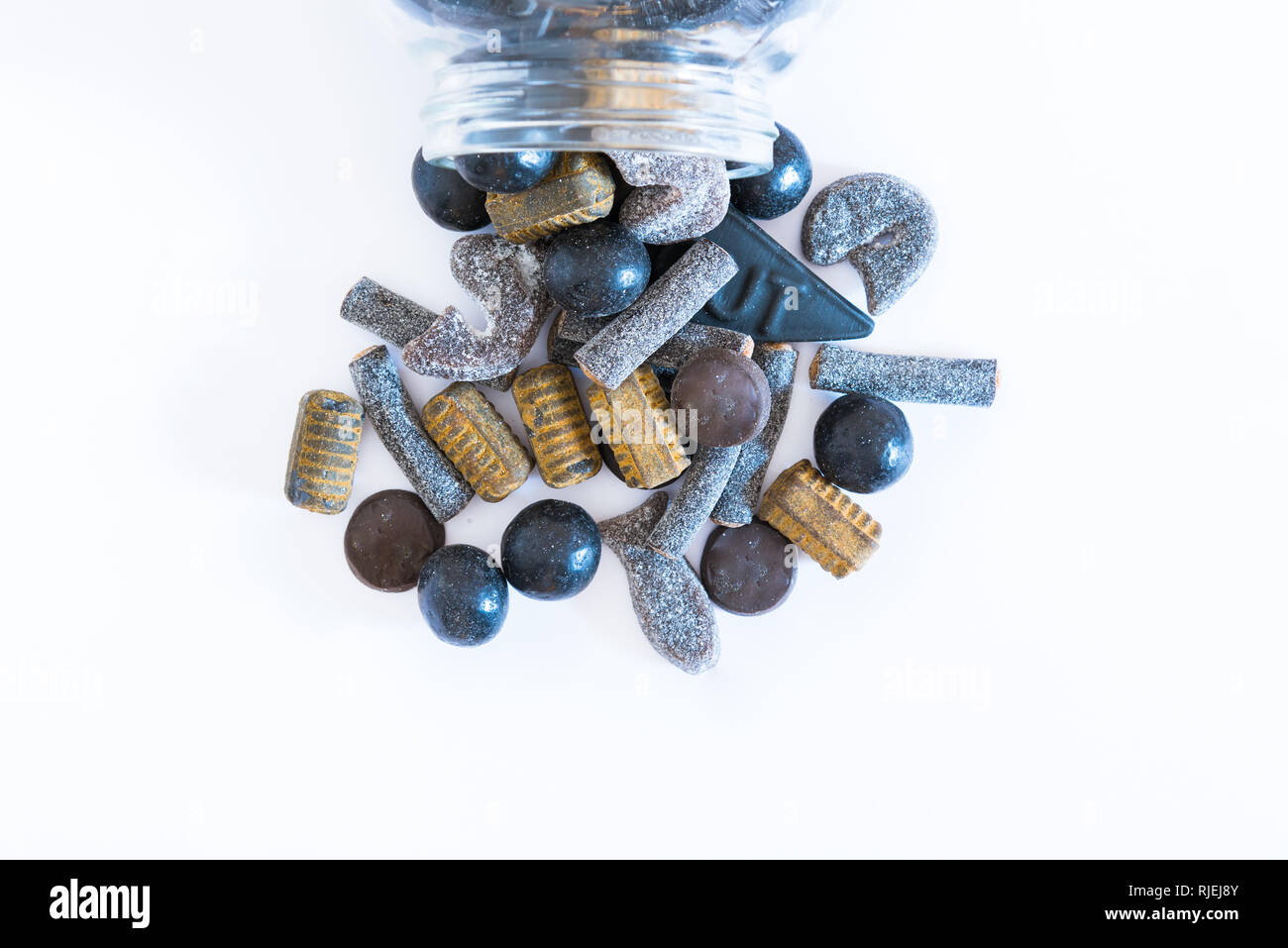 Jar assortiti di salmiakki spargimento su solidi e sfondo bianco flat -lay Foto Stock