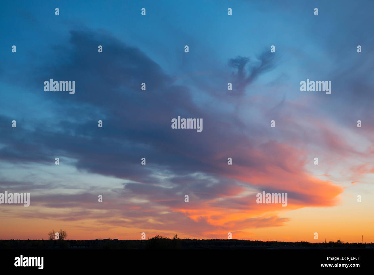 Mistico nuvole al tramonto sulla campagna in blu e toni di colore arancione Foto Stock
