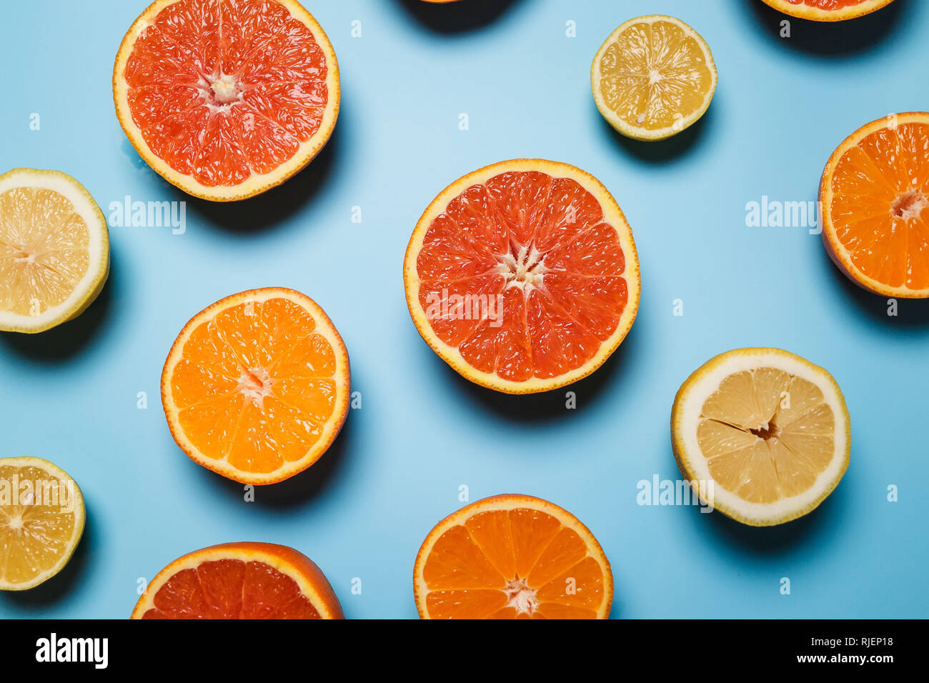 Tagliato a metà succosa agrumi su uno sfondo blu. Estate Fresca concetto con frutti tropicali. modello popolare Foto Stock