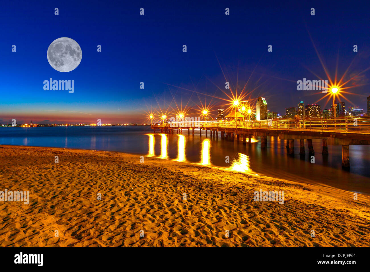 Scenic vista notturna con la luna piena a Coronado attracco a Coronado Island, California, Stati Uniti d'America. Downtown di San Diego il background. Il vecchio molo in legno Foto Stock