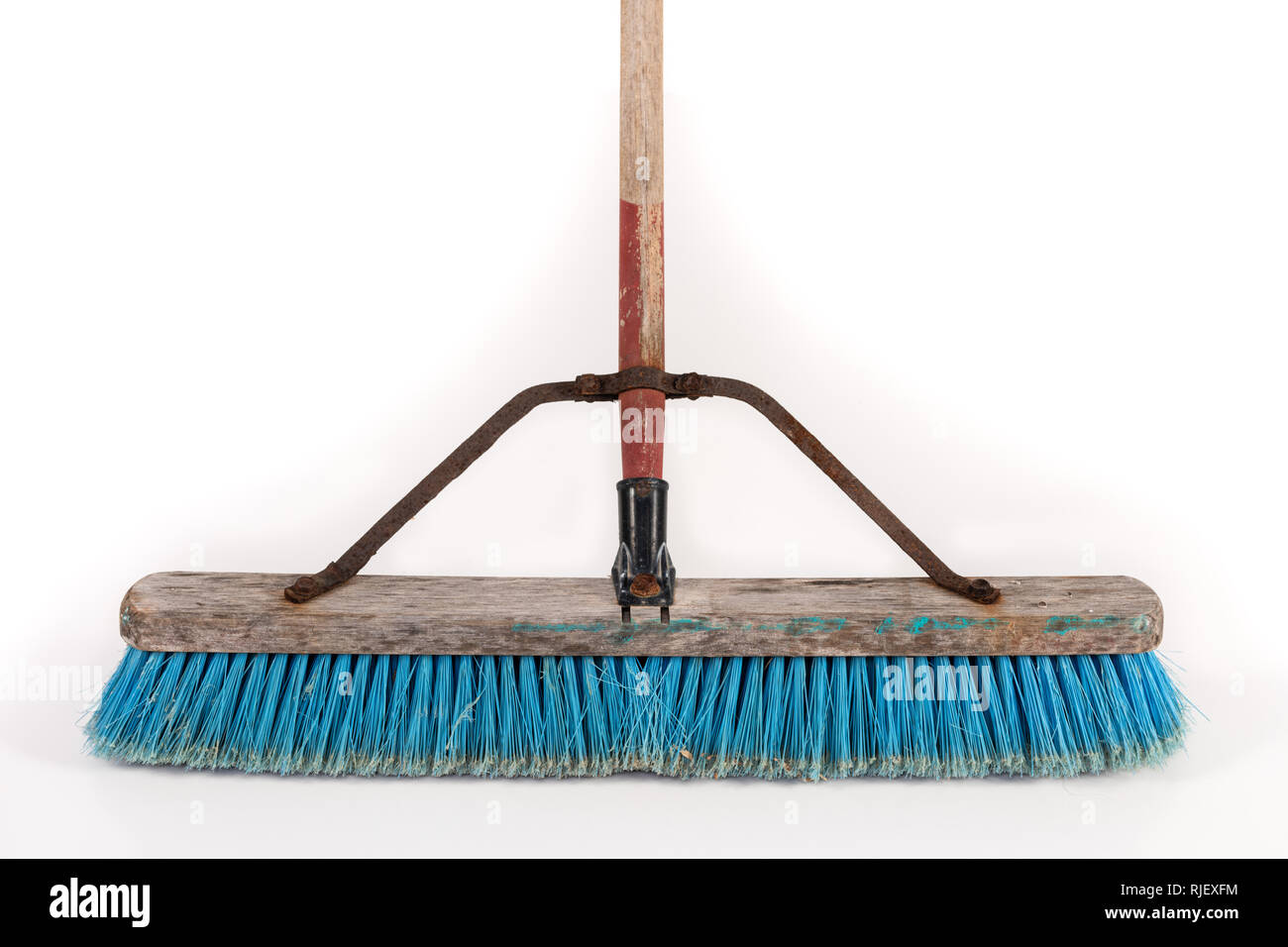 Polipropilene sporca scopa push in appoggio su una parete isolata su bianco. Foto Stock