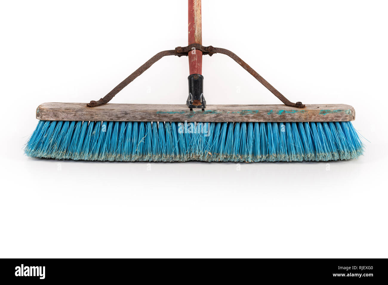 Polipropilene sporca scopa push in appoggio su una parete isolata su bianco. Foto Stock
