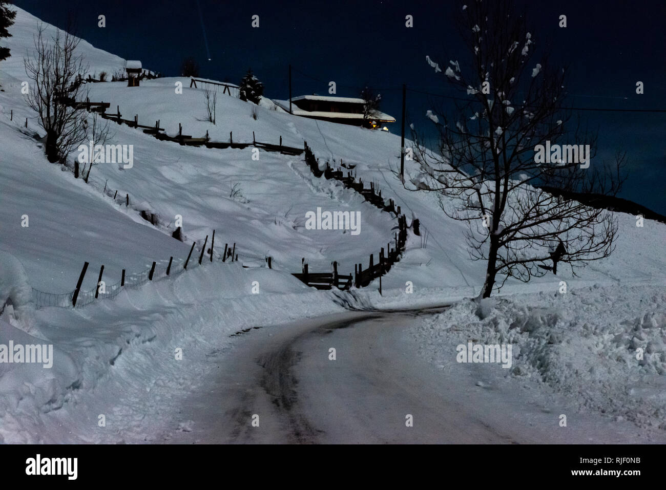 Casa delle Alpi coperte di neve durante la notte Foto Stock