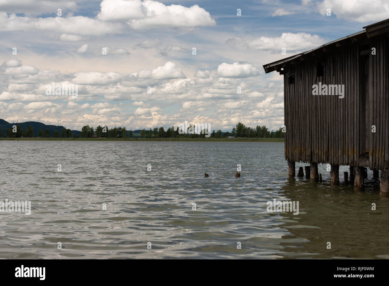 Lago calmo Kochel in Baviera con il boathouse e un cielo nuvoloso Foto Stock