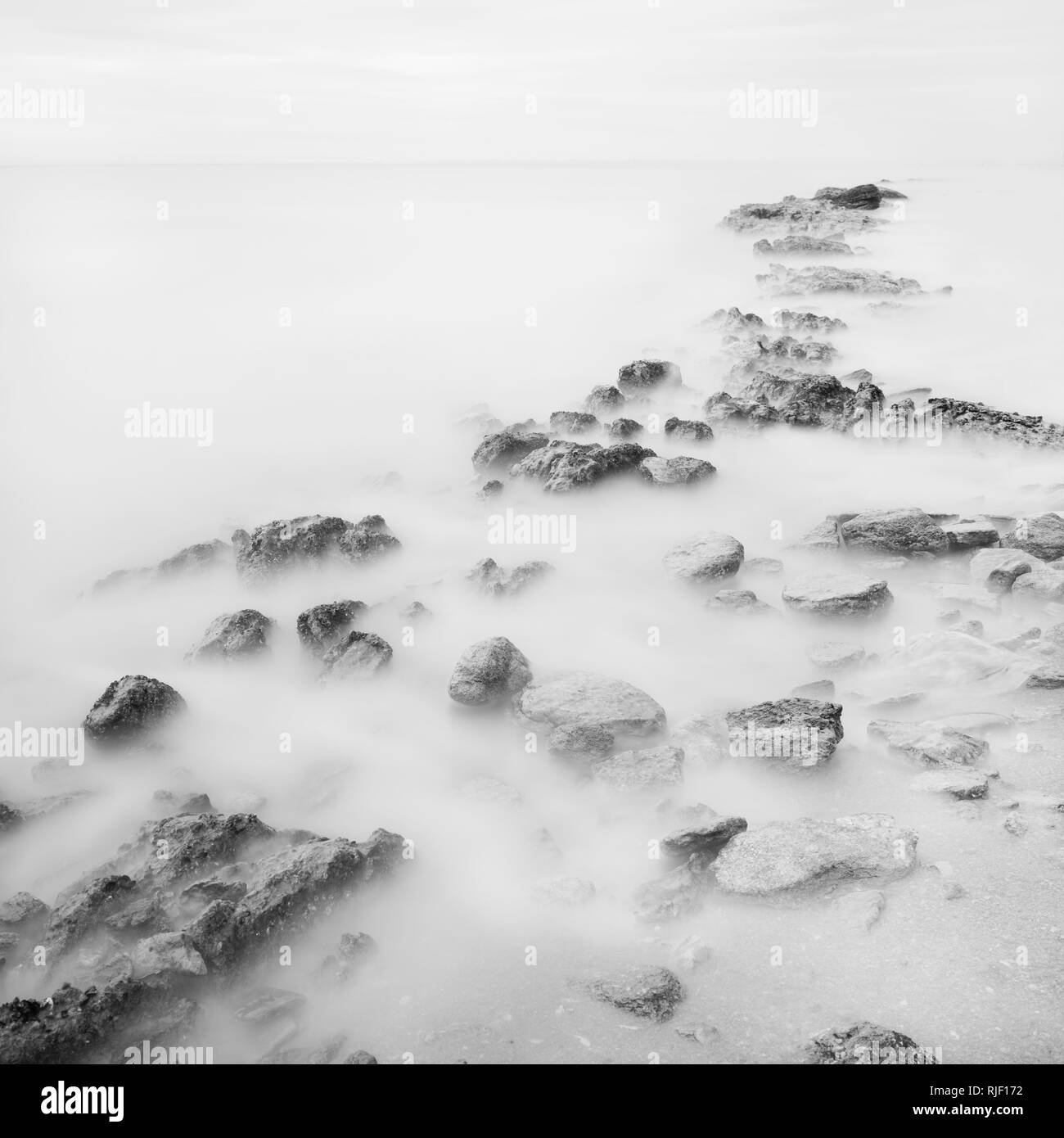 Bianco nero con lunghi tempi di esposizione paesaggio artistico. Luce, acqua e pietre prospettiva Foto Stock