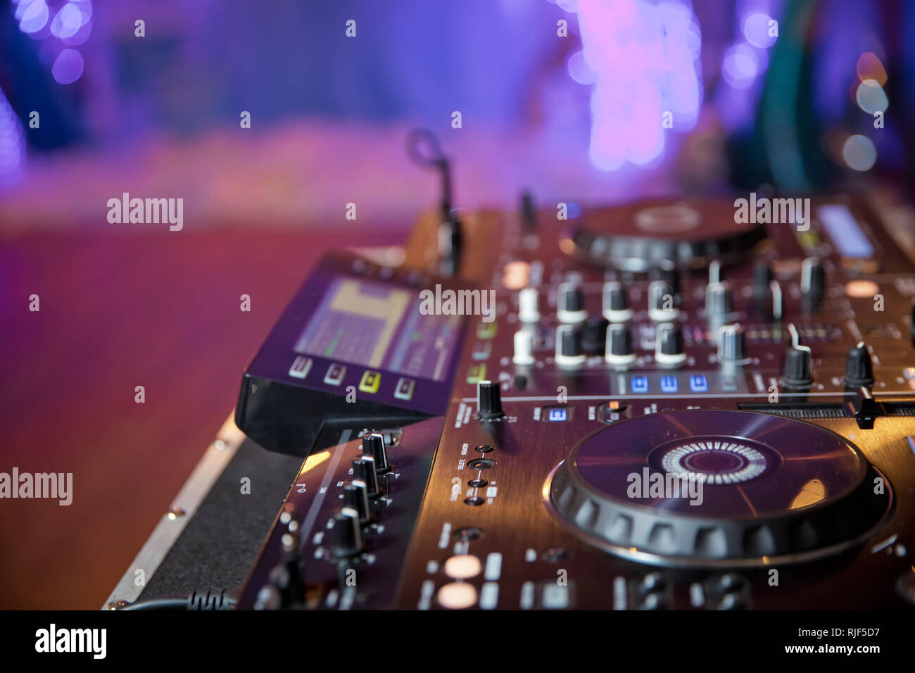 Disc jockey mixare musica sul digitale midi controller giradischi al hip hop party sul palco in night club.Mani di DJ giocare mostrano tracce di miscelazione sul mixer su Foto Stock