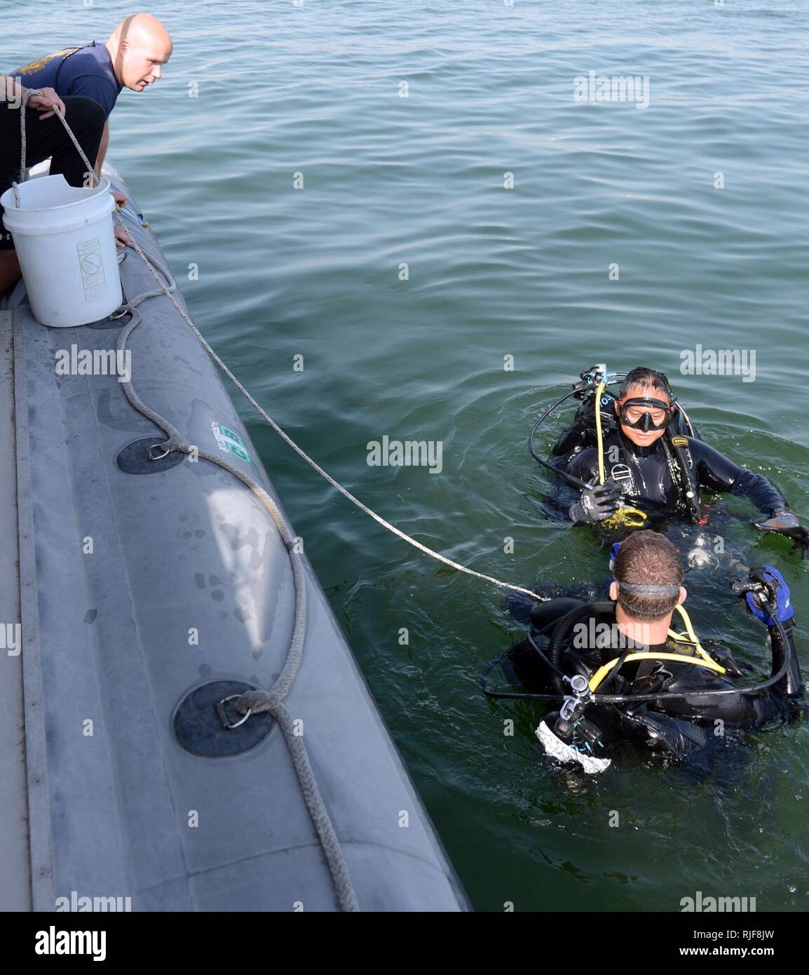 Navy Diver di terza classe Ciad Crawford, inferiore assegnato al mobile di immersioni subacquee e di unità di soccorso (MDSU) 2, Società 2-2, e la comunicazione di massa Spc. La terza classe Jumar T. Balacy, assegnato al combattimento della flotta del Pacifico della fotocamera, ricevere istruzioni dal Navy Diver 1a classe Ryan Marsh prima di condurre una routine anti-terrorismo protezione forza di immersione. MDSU 2 è assegnato al comandante, gruppo di attività 56.1, promuovendo la contromisura mine, l'eliminazione degli ordigni esplosivi, recupero immersioni e forza di protezione negli Stati Uniti Quinta Flotta area di responsabilità. Foto Stock