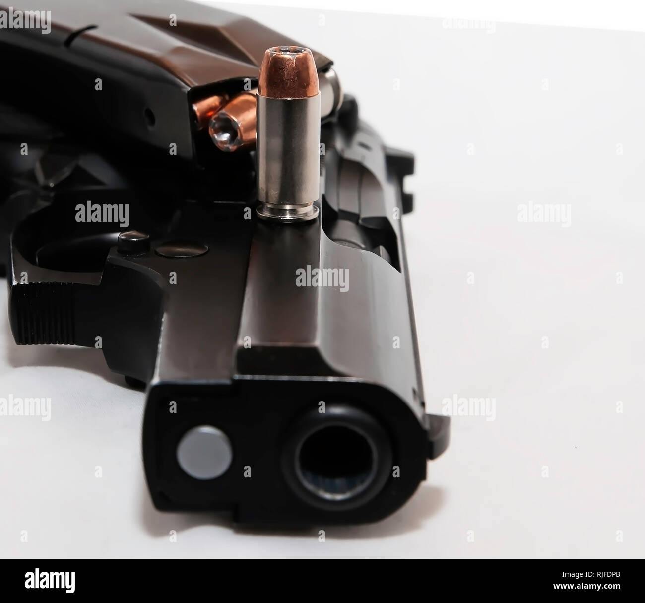 Un nero 40 pistola calibro di lato con una pistola carica rivista sulla sommità di esso con un unico 40 caliber bullet su sfondo bianco Foto Stock