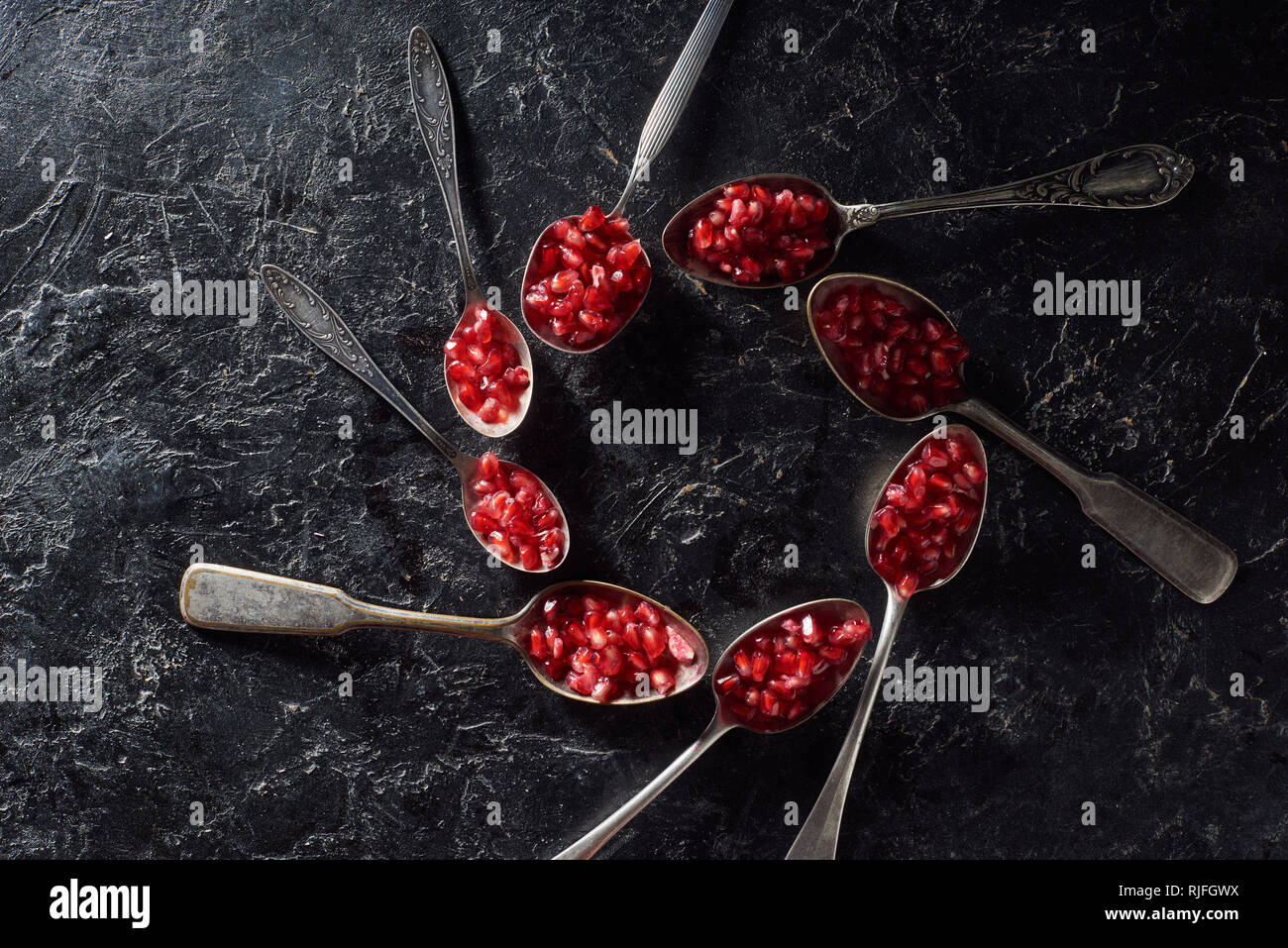 Lay piatto con i semi di melograno in cucchiai Foto Stock