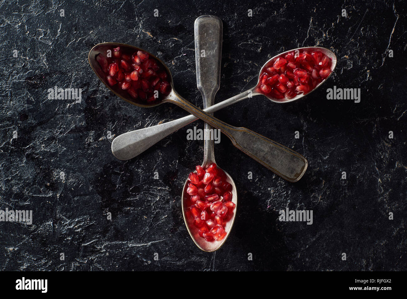 Piatto con laici attraversato i cucchiaini e semi di granato Foto Stock