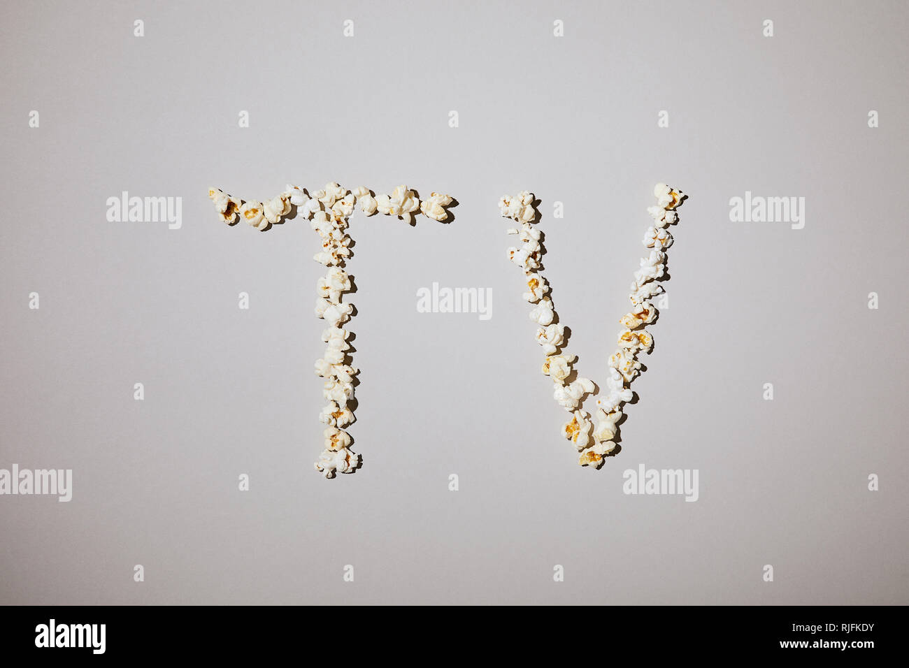 Lay piatto di gustoso popcorn con tv lettering isolato su bianco Foto Stock
