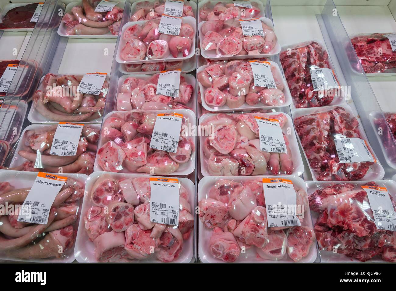 La carne di maiale code, zampe di maiale e piccole carni imballate in plastica nel supermercato, Monaco di Baviera, Baviera, Baviera, Germania Foto Stock