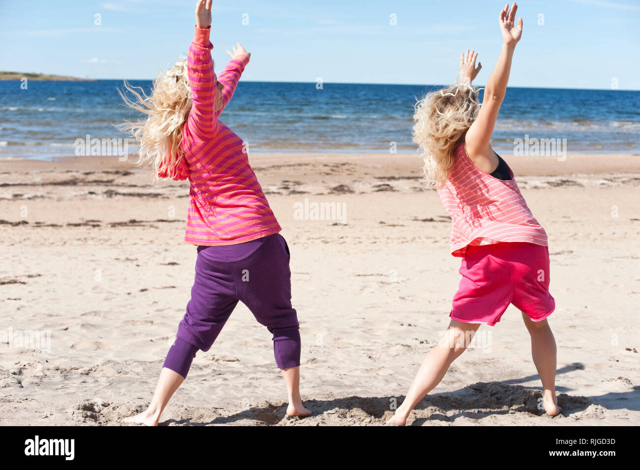 Giovani donne stiramento sulla spiaggia Foto Stock