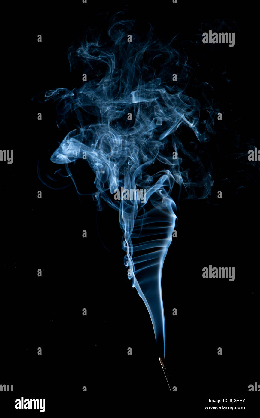 Emissione di fumo bianco volute su sfondo nero Foto Stock